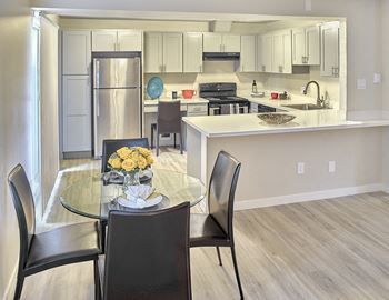an open kitchen and dining area with a glass table and chairs  at 3030 Lake City, Seattle, WA